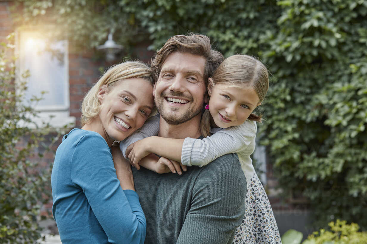 Portrait of happy family in garden of their home